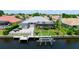 Aerial view of the house with canal access, featuring a dock, boat lift, screen enclosed pool and back deck at 9810 Compass Point Way, Tampa, FL 33615