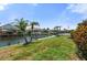 Lush waterfront backyard, featuring a boat lift, dock, and direct water access, perfect for the boating enthusiast at 9810 Compass Point Way, Tampa, FL 33615
