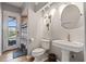 Bathroom with a pedestal sink, a mirror and a shower. Access to pool is visible through the door at 9810 Compass Point Way, Tampa, FL 33615