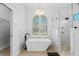 Contemporary bathroom showcasing a sleek standalone tub, marble walls, and a glass-enclosed shower at 9810 Compass Point Way, Tampa, FL 33615