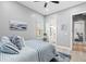 Comfortable bedroom with blue and white bedding, a ceiling fan, and a view into the bathroom at 9810 Compass Point Way, Tampa, FL 33615