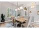 Bright dining room with elegant lighting, wooden table with seating for six, and large windows with plantation shutters at 9810 Compass Point Way, Tampa, FL 33615