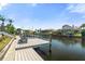 Inviting waterfront dock with chairs and boat lift, perfect for relaxing by the water and enjoying the serene view at 9810 Compass Point Way, Tampa, FL 33615