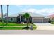 Charming single-story home with a manicured lawn, three-car garage, and inviting curb appeal at 9810 Compass Point Way, Tampa, FL 33615