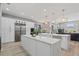 Bright kitchen boasts white cabinets, marble countertops, stainless steel appliances, and overlooks the living area at 9810 Compass Point Way, Tampa, FL 33615