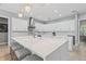 Bright kitchen boasts white cabinets, marble countertops, brass hardware, and a large island with seating at 9810 Compass Point Way, Tampa, FL 33615