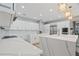 Bright kitchen boasts white cabinets, marble countertops, stainless steel appliances, and a large island with seating at 9810 Compass Point Way, Tampa, FL 33615