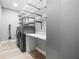 Functional laundry room fitted with modern washer, dryer, shelving and a folding table at 9810 Compass Point Way, Tampa, FL 33615