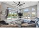 Open living area with high ceilings, expansive windows, a ceiling fan, and plush furniture at 9810 Compass Point Way, Tampa, FL 33615
