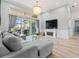 Bright living room with a gray sectional sofa, modern fireplace, large windows with a view of the pool and outdoor space at 9810 Compass Point Way, Tampa, FL 33615
