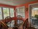 Dining area offers a glass table, shutters, and access to a cozy outdoor screened porch at 6339 Delaware Ave, New Port Richey, FL 34653