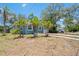 Charming home featuring a well-kept lawn and beautiful landscaping, complemented by a bright blue exterior at 1000 Magnolia Dr, Clearwater, FL 33756