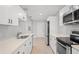 Modern kitchen featuring stainless steel appliances, white cabinets, and stone countertops at 1000 Magnolia Dr, Clearwater, FL 33756