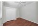 Bright bedroom features wood floors, a ceiling fan, and a large double-door closet at 10344 Tecoma Dr, Trinity, FL 34655