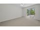 Carpeted bedroom featuring a large glass sliding door to outside patio at 10344 Tecoma Dr, Trinity, FL 34655
