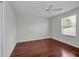 Vacant bedroom features hardwood floors, neutral paint, a ceiling fan and a window at 10344 Tecoma Dr, Trinity, FL 34655