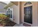 Welcoming front door with sidelight window, decorative hardware, and dark-colored welcome mat at 10344 Tecoma Dr, Trinity, FL 34655