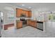 Kitchen features stainless appliances, granite counters, and white marble-patterned tile floors at 10344 Tecoma Dr, Trinity, FL 34655