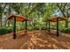 Outdoor picnic area with wood mulch flooring, wooden picnic tables and shade in a lush outdoor setting at 10344 Tecoma Dr, Trinity, FL 34655