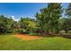 Community park featuring a playground, swings, mature shade trees, and a vast expanse of green space at 10344 Tecoma Dr, Trinity, FL 34655