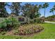 Community sign 'Fox Wood at Trinity' amid colorful flowers, plants, and manicured lawn at 10344 Tecoma Dr, Trinity, FL 34655