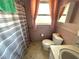 Compact bathroom featuring a toilet, vanity with a sink, and a shower area with a gray and white striped curtain at 10431 Syringa Ct, Port Richey, FL 34668