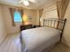 Comfortable bedroom with natural light, ceiling fan, desk, and a metal frame bed covered with a white quilt at 10431 Syringa Ct, Port Richey, FL 34668