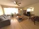 Inviting living room featuring a ceiling fan, comfortable seating, and natural light, great for relaxation at 10431 Syringa Ct, Port Richey, FL 34668
