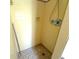 Simple yellow-tiled shower with handheld shower head and tiled floors at 10431 Syringa Ct, Port Richey, FL 34668