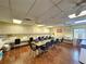 Bright activity room with tables, chairs, sewing machines, cabinets, and wood floors at 11141 Sandtrap Dr # 11141, Port Richey, FL 34668