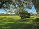 Expansive backyard featuring lush green grass and mature trees, perfect for outdoor activities and relaxation at 11141 Sandtrap Dr # 11141, Port Richey, FL 34668
