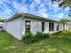 Exterior backyard featuring green grass and the side of the home with multiple windows at 11141 Sandtrap Dr # 11141, Port Richey, FL 34668