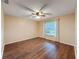 Empty bedroom with ceiling fan, hardwood floors, and a window with curtains at 11141 Sandtrap Dr # 11141, Port Richey, FL 34668
