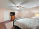 Bright bedroom featuring a ceiling fan, dresser with TV, and closet with white door at 11141 Sandtrap Dr # 11141, Port Richey, FL 34668