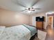 Bedroom with ceiling fan, dresser with TV, and wood floors leading to hallway at 11141 Sandtrap Dr # 11141, Port Richey, FL 34668