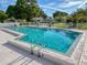 Community pool surrounded by a white fence with steps and a ladder for access to the inviting blue water at 11141 Sandtrap Dr # 11141, Port Richey, FL 34668