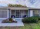 Inviting screened front porch with comfortable seating and well-maintained landscaping at 11141 Sandtrap Dr # 11141, Port Richey, FL 34668