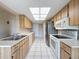 The kitchen has wood cabinets, white tile flooring, and stainless steel appliances at 11141 Sandtrap Dr # 11141, Port Richey, FL 34668