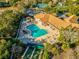 Aerial view of pool with lounge chairs and umbrellas in a community with tennis courts at 11350 Copley Ct, Spring Hill, FL 34609