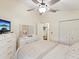 Cozy bedroom featuring a ceiling fan, closet, and view to the en suite bathroom at 11350 Copley Ct, Spring Hill, FL 34609