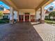 Inviting building entrance with brick pillars, red doors, and a covered walkway for easy access at 11350 Copley Ct, Spring Hill, FL 34609