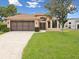 Charming, single-story home with lush landscaping and an arched entryway at 11350 Copley Ct, Spring Hill, FL 34609