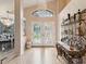 Grand foyer with elegant chandelier, stylish decor, and decorative glass front doors at 11350 Copley Ct, Spring Hill, FL 34609
