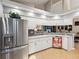 Bright kitchen features white cabinets, stainless steel appliances, granite countertops, and an eat-in bar at 11350 Copley Ct, Spring Hill, FL 34609