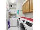 Well-organized laundry room with washer, dryer, utility sink, storage cabinets, and shelving at 11350 Copley Ct, Spring Hill, FL 34609