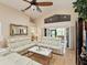 Living room features vaulted ceiling, fan, luxury furniture and an ample opening to an enclosed patio at 11350 Copley Ct, Spring Hill, FL 34609