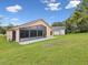 Enjoy Florida living with this screened lanai and paved patio, set in a lush, green backyard with blue skies at 11350 Copley Ct, Spring Hill, FL 34609