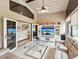 Sunroom featuring a tan couch, vaulted ceilings and view to additional rooms at 11350 Copley Ct, Spring Hill, FL 34609