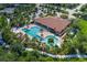 Aerial view of the community pool, lazy river, and clubhouse surrounded by lush trees at 11611 Callisia Dr, Odessa, FL 33556