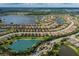 Drone's eye view of a community with lakefront properties and a manicured central park with tropical landscaping features at 11611 Callisia Dr, Odessa, FL 33556